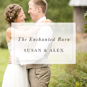 couple smiling at each other infront of The Enchanted Barn in Hillsdale, WI