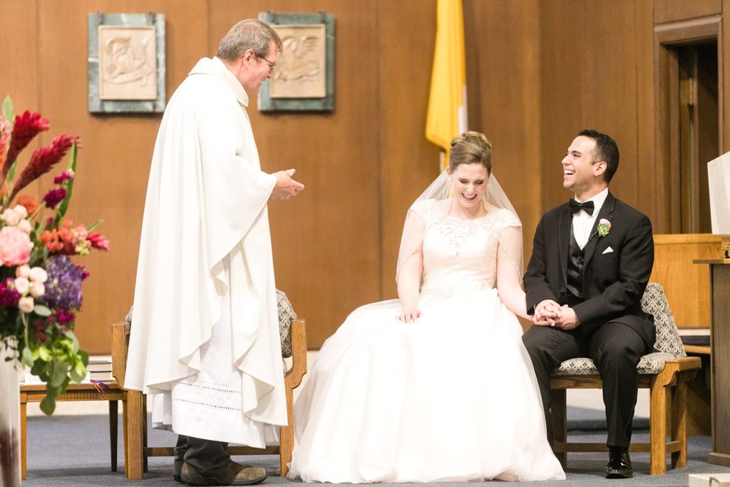 priest with couple laughing at their wedding at Immaculate Conception in Eau Claire
