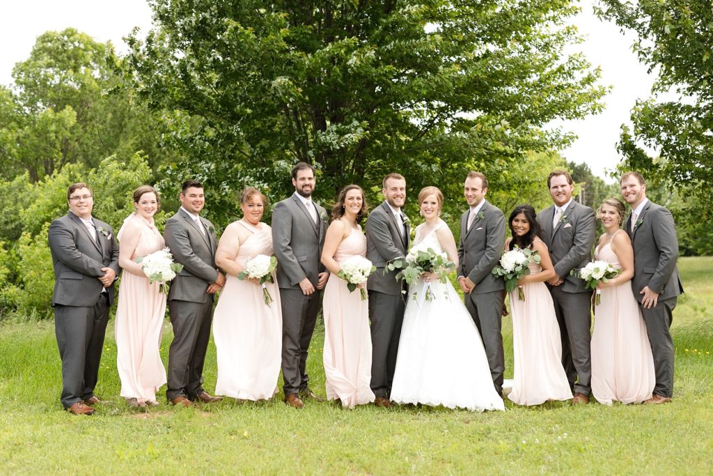 bridal party smiling at the camera at wedding atThe Florian Gardens in Eau Claire