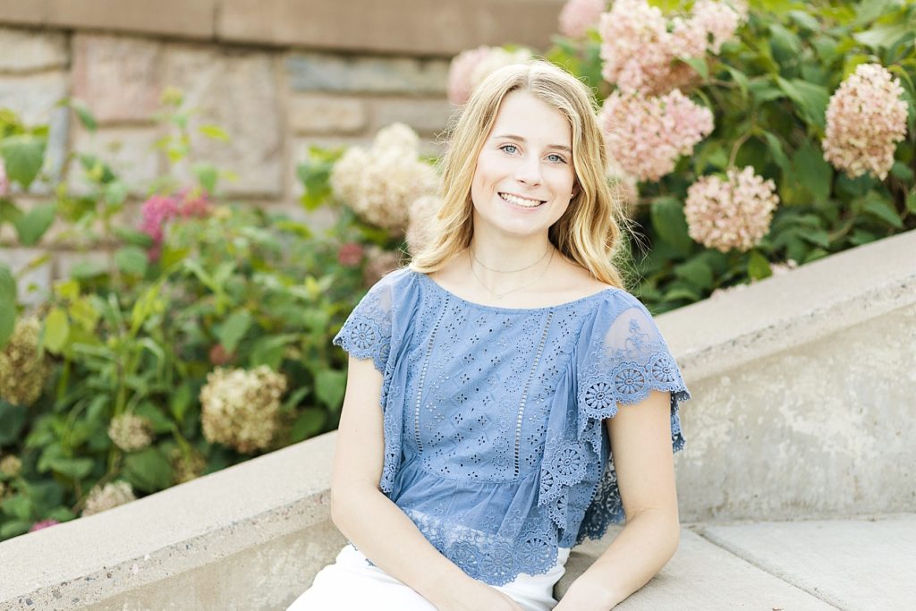 Phoenix Park Senior Photos in Eau Claire, girl leaning against stairs with hydrangeas in the background