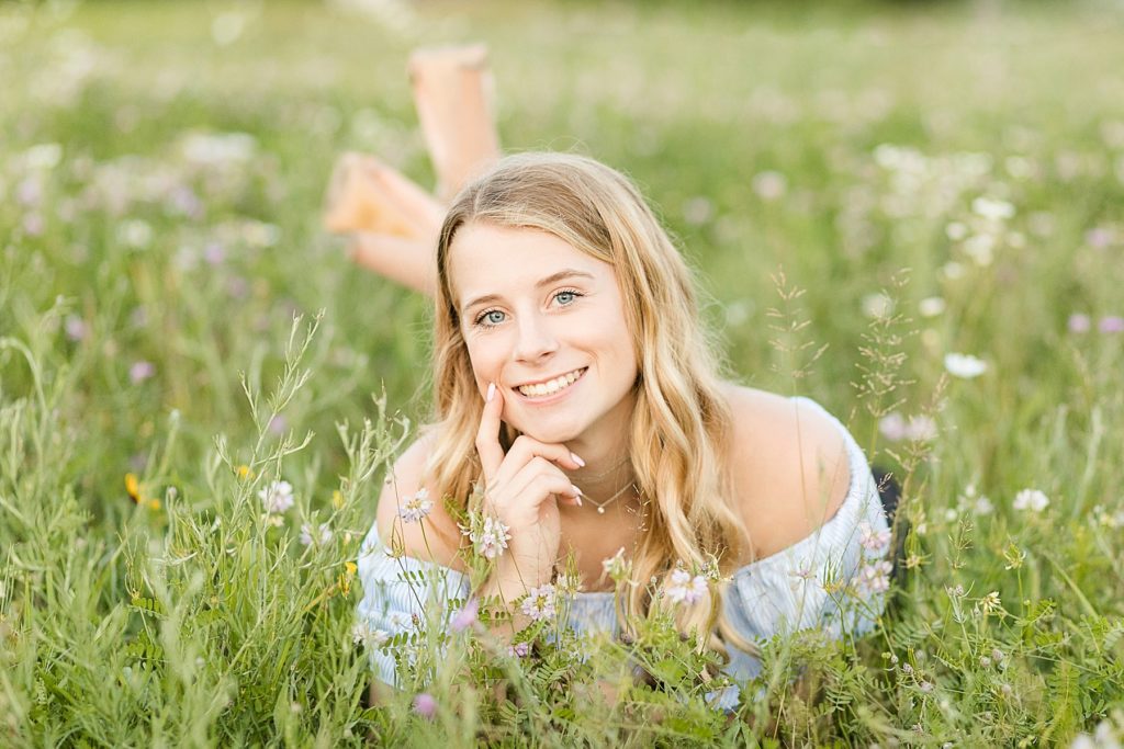 girl laying on stomach in a field of flowers in Eau Claire