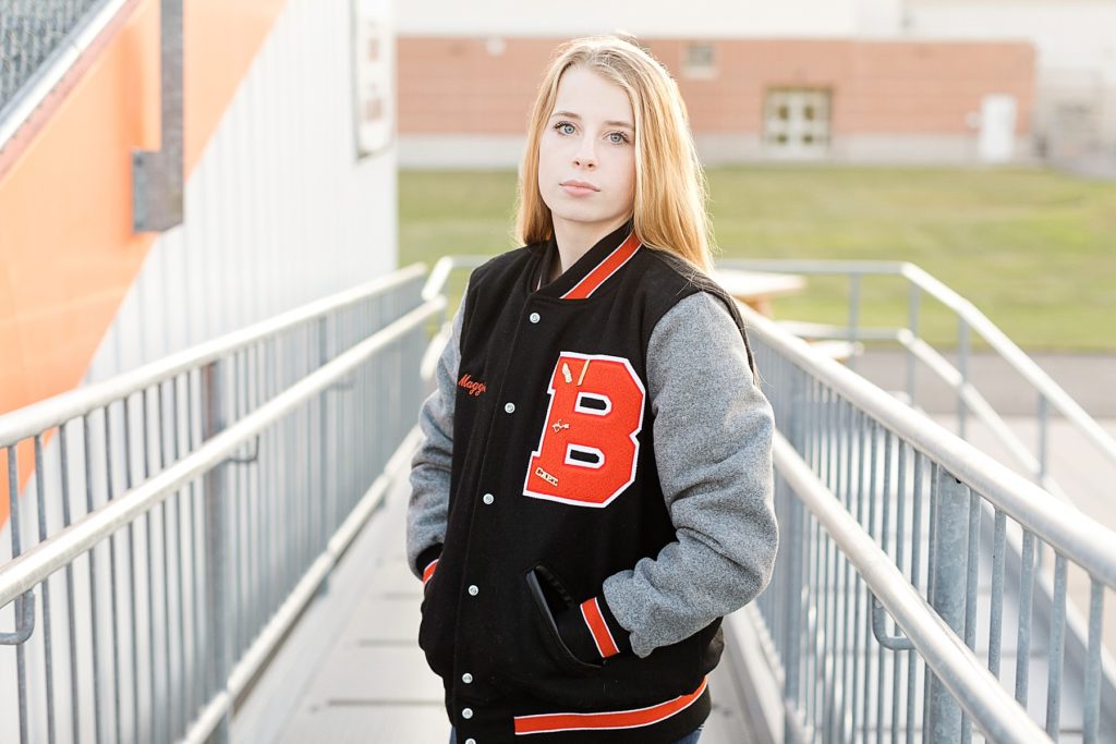 girl in bleachers with Bloomer Blackhawks lettermans jacket on
