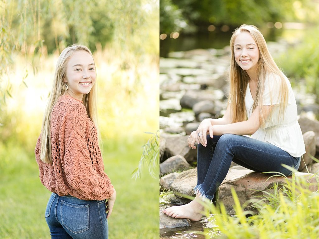 girl looking back in an orange sweater and in a white top and jeans on a rock in a creek for her Eau Claire boho senior photos