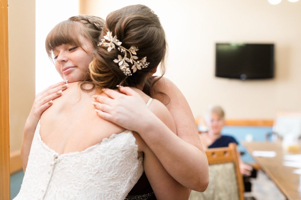bride and sister hugging after getting ready at the Glacier Canyon Conference Center for a wedding at the Wilderness Resort in Wisconsin Dells