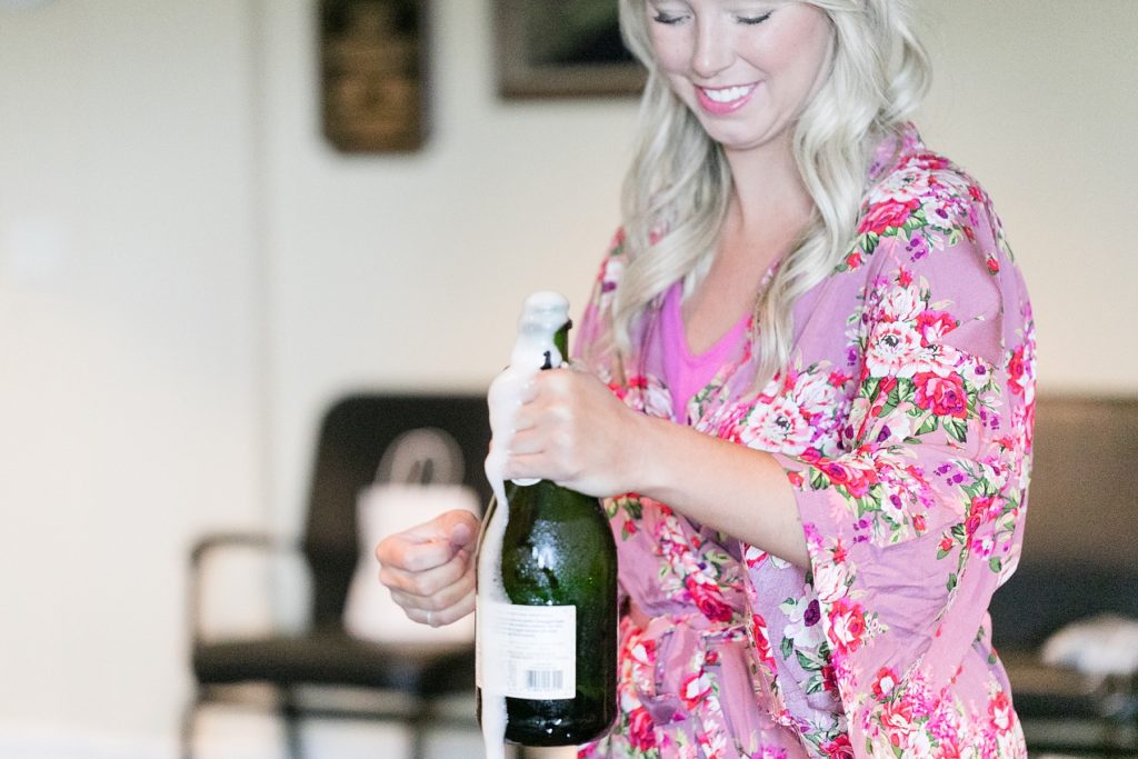 bridesmaid popping a champagne bottle for mimosas at Lake Wissota Golf & Events