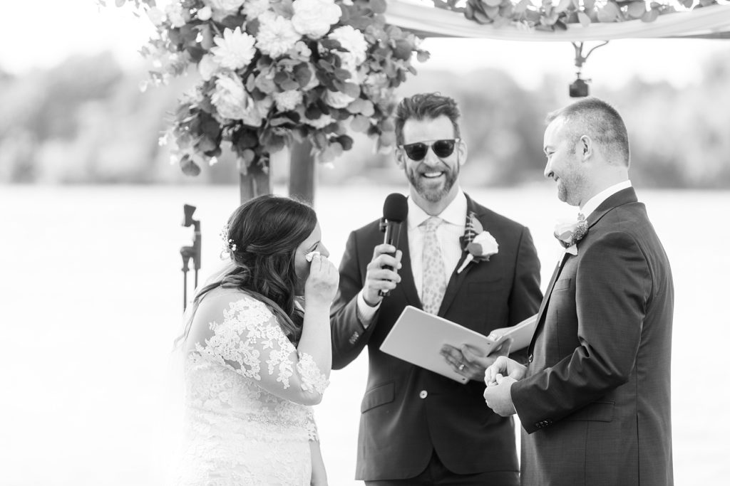 bride wiping her tears while the groom says his vows at Lake Wissota Golf & Events
