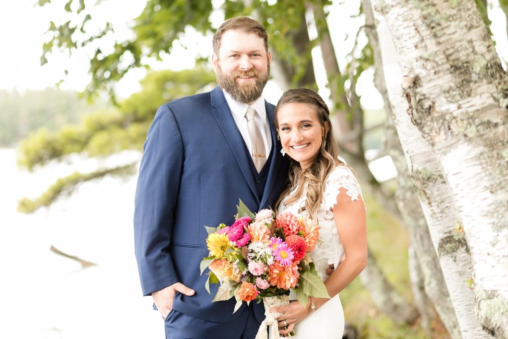 bride and groom smiling standing infront of the lake at The Beacons of Minocqua on their wedding day