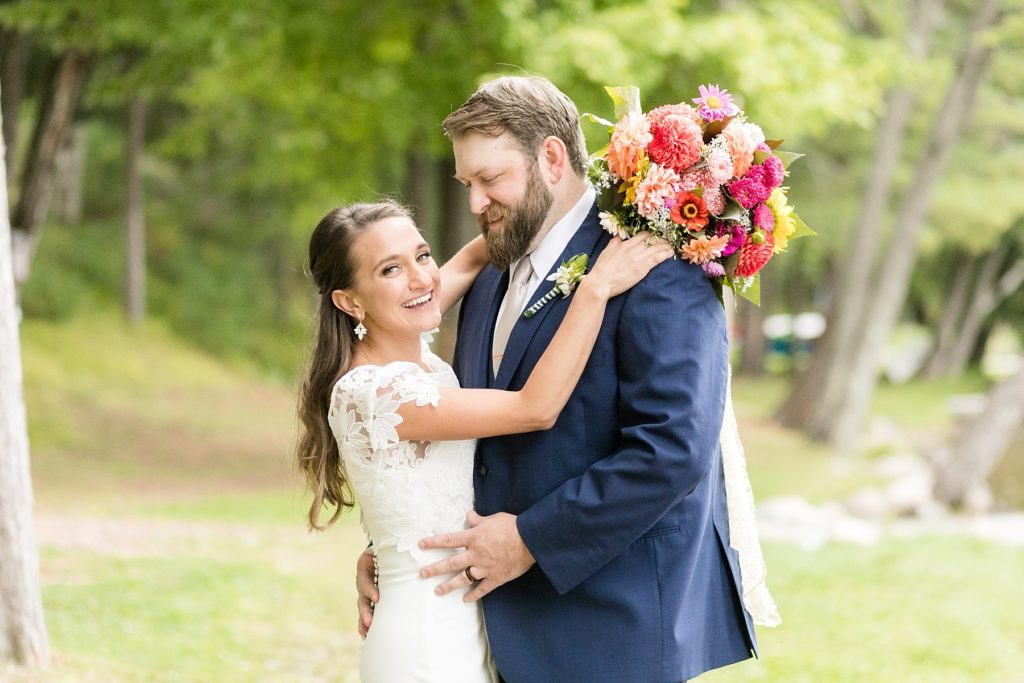 bride and groom smiling with a bright bouquet at The Beacons of Minocqua on their wedding day