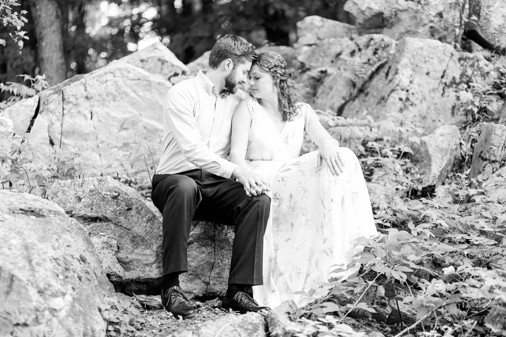 couple sitting on rocks at Rib Mountain State Park in Wausau for their engagement pictures