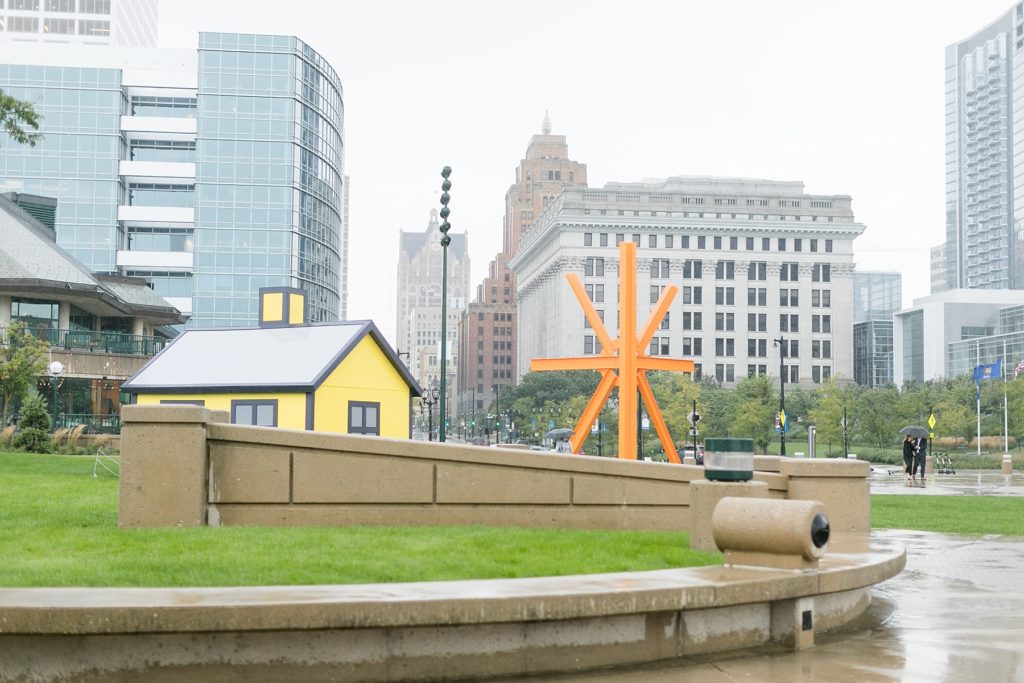 couple walking towards the Milwaukee Art Museum in the rain where he is about to propose