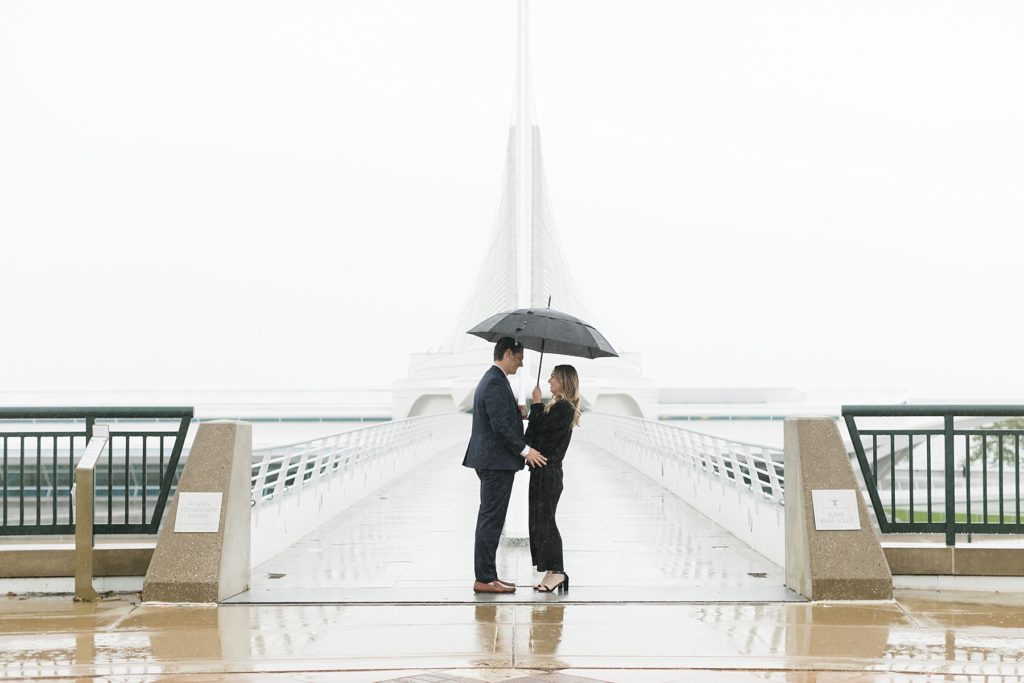 couple standing in the rain where guy is about to propose at the Milwaukee Art Museum