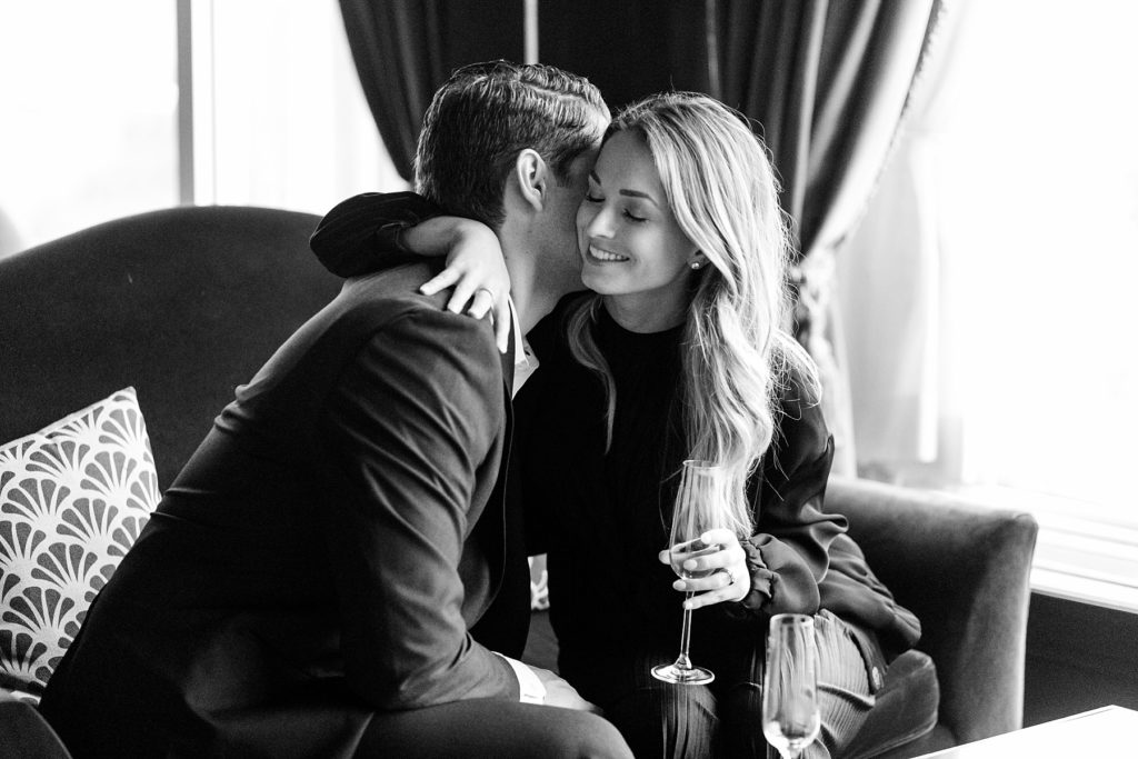 couple hug in black and white photo on a couch in Blu at the top of the Pfister Hotel in Milwaukee