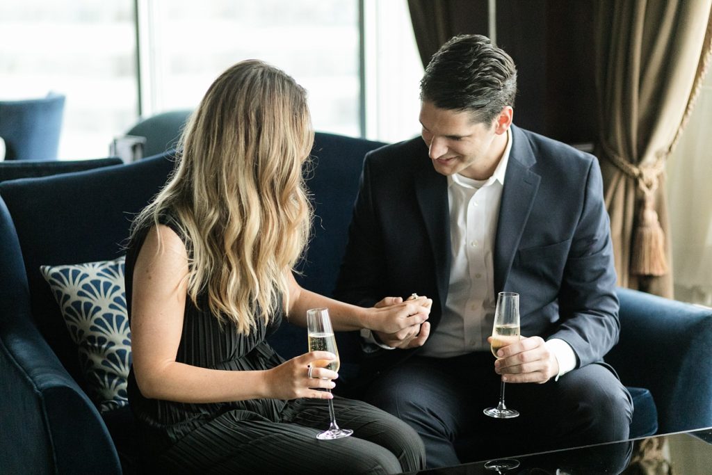 man looking at fiances new ring after he proposed in Blu at the top of the Pfister Hotel in Milwaukee