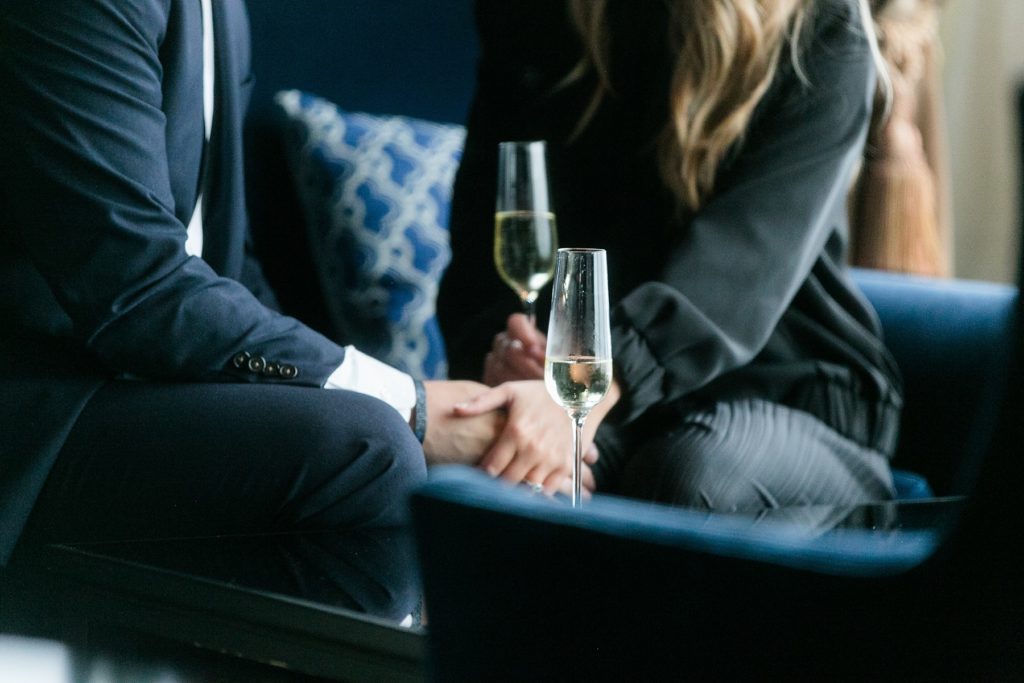 couple holds hands in Blu at the top of the Pfister Hotel in Milwaukee