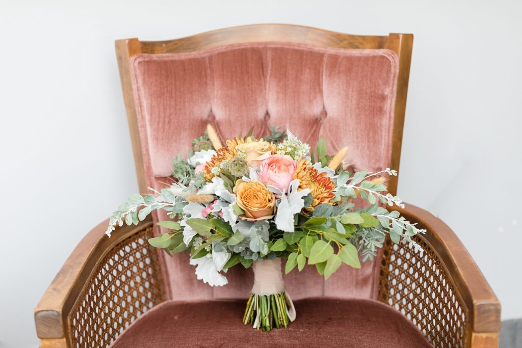brides bouquet on a pink velvet chair in a church in Chippewa Falls.  Bouquet by Fersk Floral Artistry