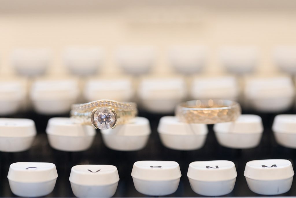 couples rings on a typewriter at their wedding at the Oxbow Hotel in Eau Claire