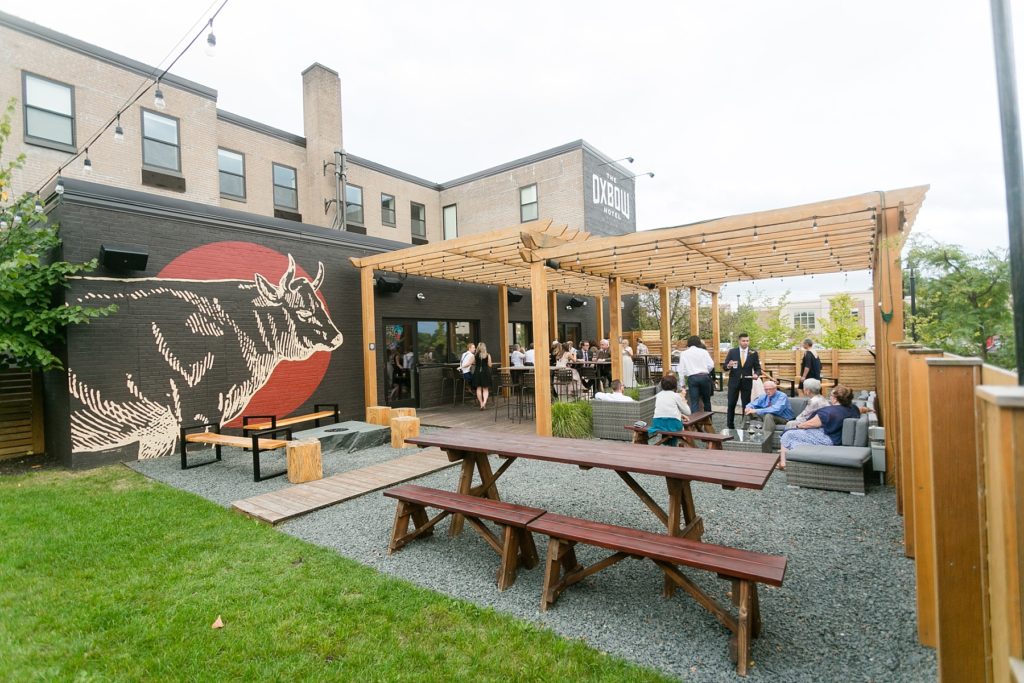 guests on the patio for cocktail hour at their wedding at the Oxbow Hotel in Eau Claire