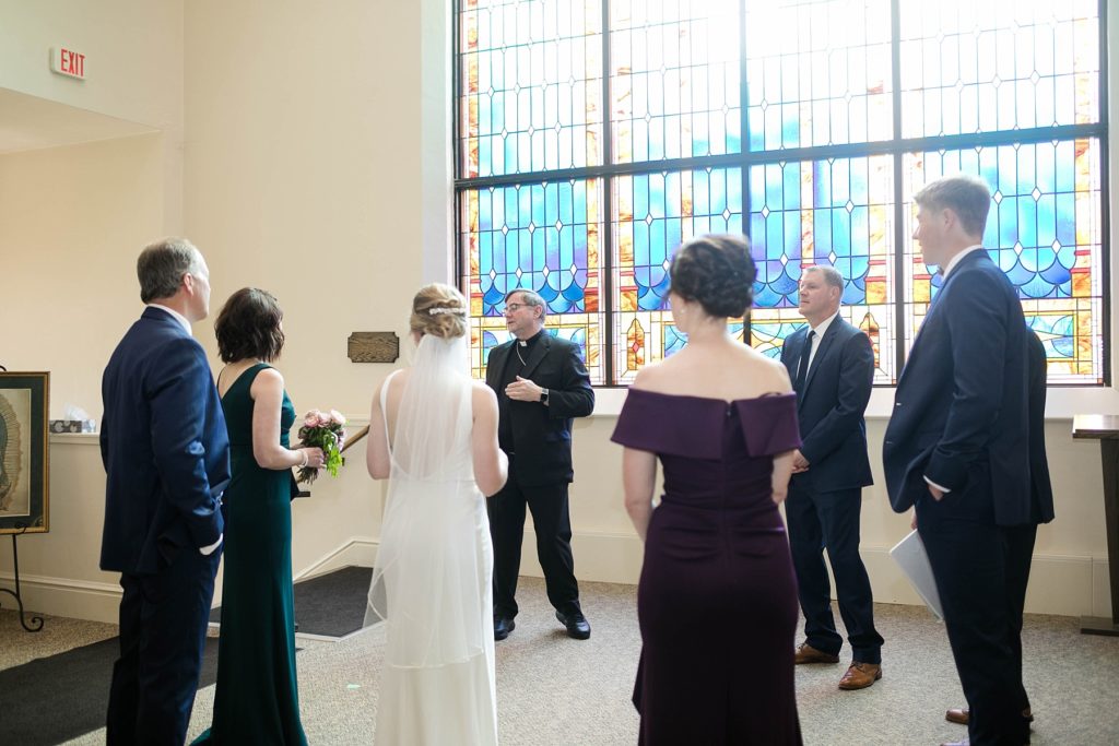 Bishop James Powers talking with the bride, groom and their families before performing his first pandemic wedding ceremony at St. Joseph Catholic Church in Rice Lake, WI