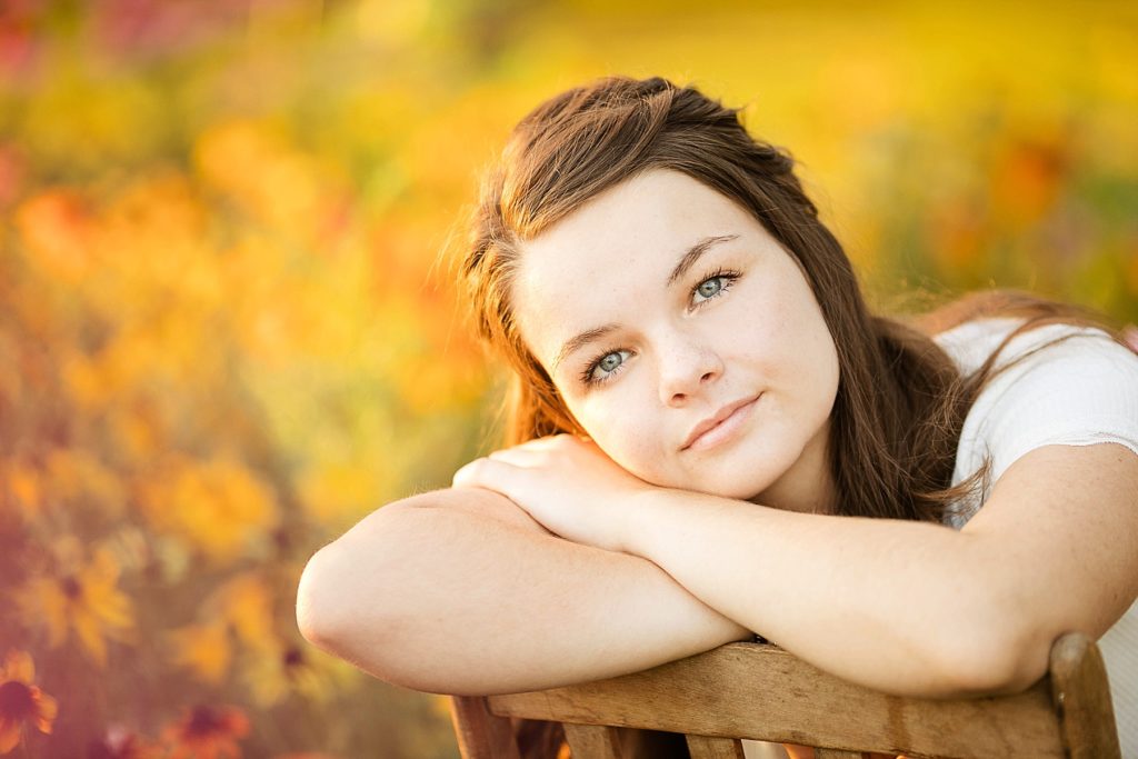 girl leaning on a chair for her boho senior session in Eau Claire, WI