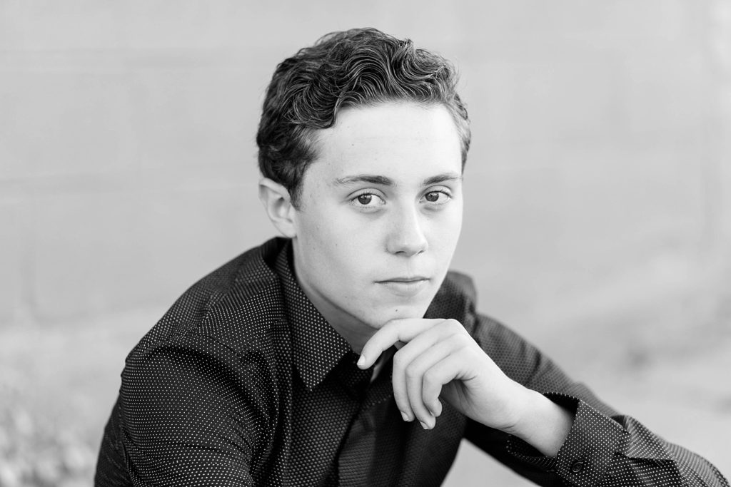 boy in a black and white photo with a pensive look downtown Chippewa Falls for his senior pictures