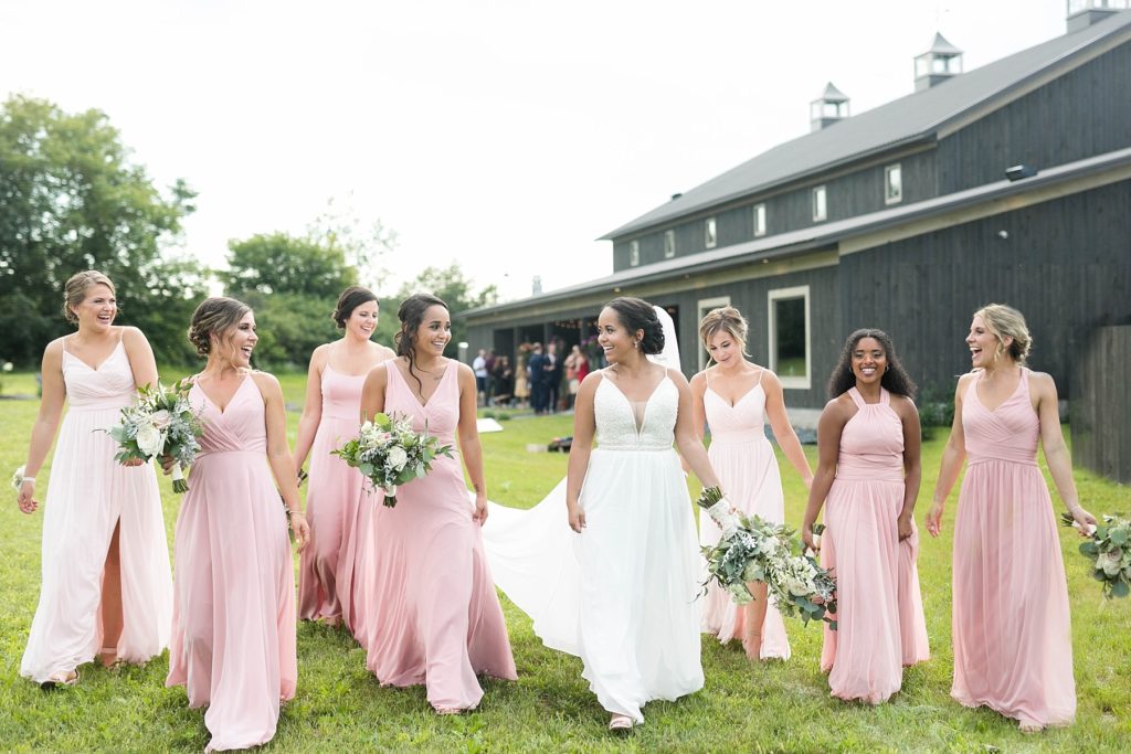 bride and bridesmaids walking with venue behind them at Lilydale in Chippewa Falls, WI