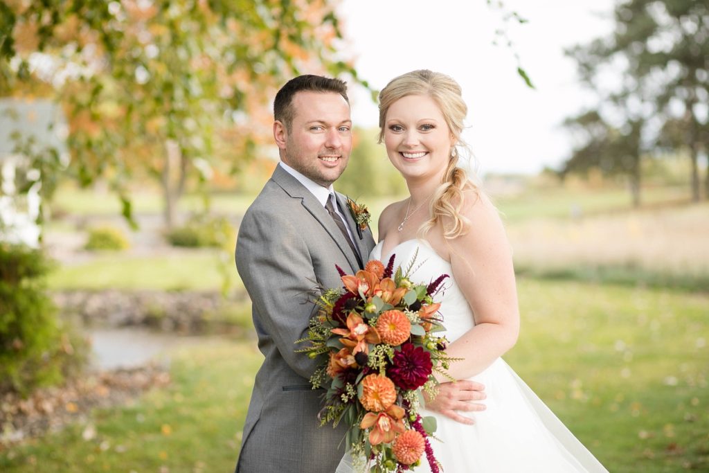 bride and groom smiling on the golf course at a wedding at Lake Wissota Golf & Events
