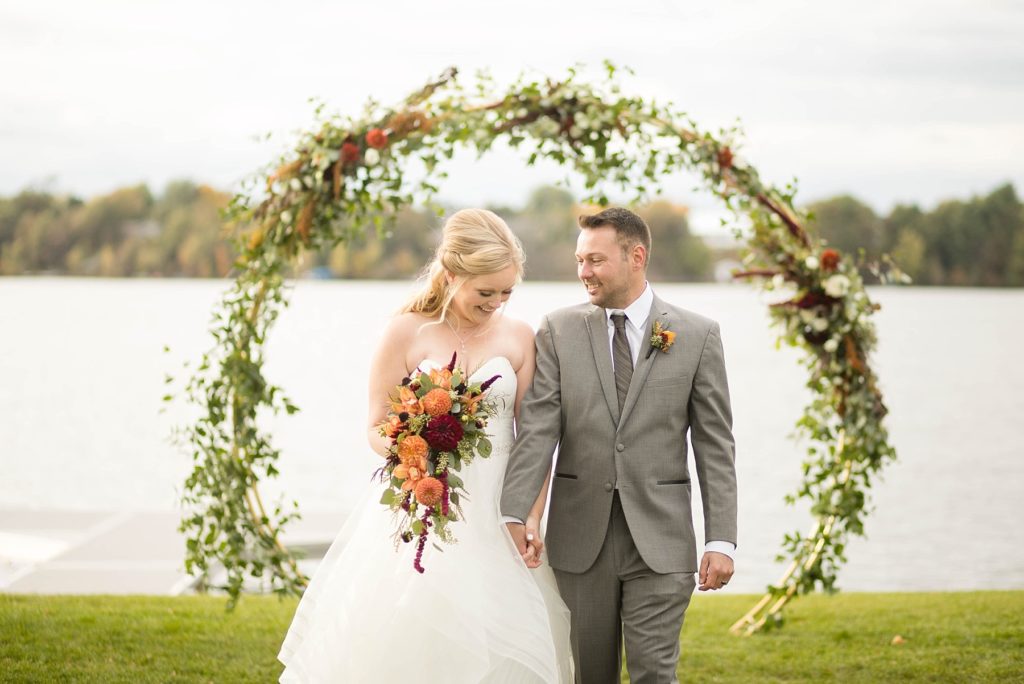 couple under floral arch at a wedding at Lake Wissota Golf & Events by Allure Premiere Event Florists