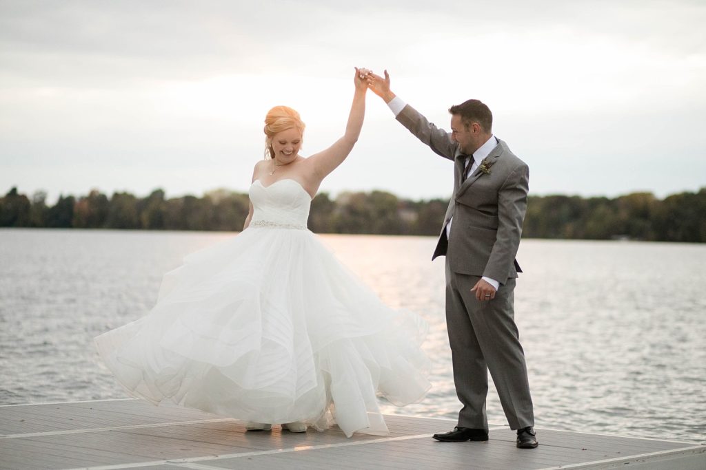 couple twirling on the dock at sunset at a wedding at Lake Wissota Golf & Events