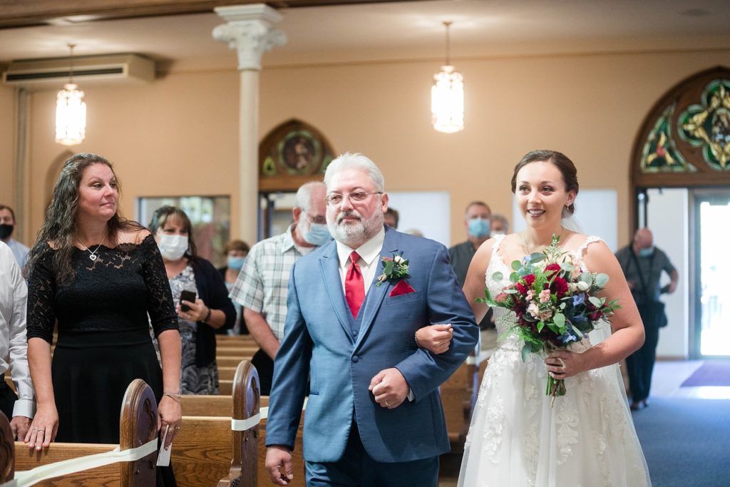 father walking daughter down the aisle at stunning wedding in Marathon, WI at St. Mary's Catholic Church
