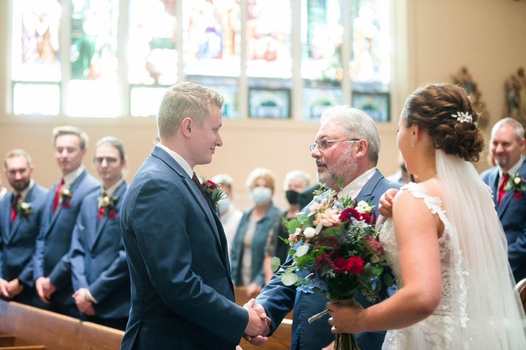 father giving the daughter away at stunning wedding in Marathon, WI at St. Mary's Catholic Church