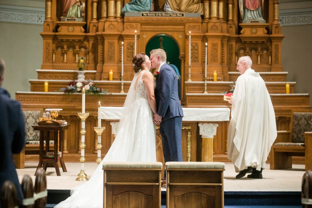 first kiss at stunning wedding in Marathon, WI at St. Mary's Catholic Church
