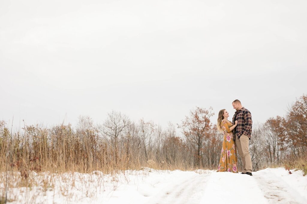 couple standing in meadow for their winter engagement session in Ladysmith