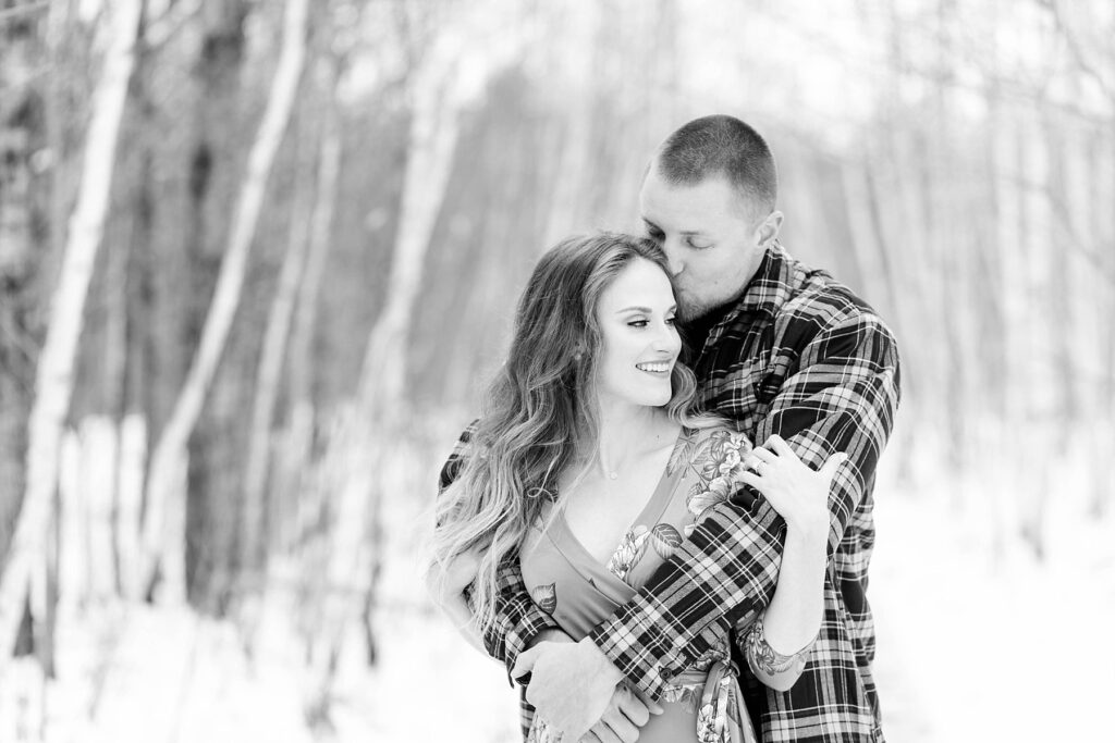 couple holding each other in a black and white photo for their winter engagement session in Ladysmith