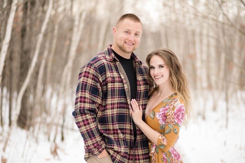 couple smiling at the camera for their winter engagement session in Ladysmith