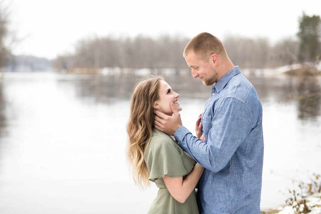 couple standing on the riverbank for their winter engagement session in Ladysmith