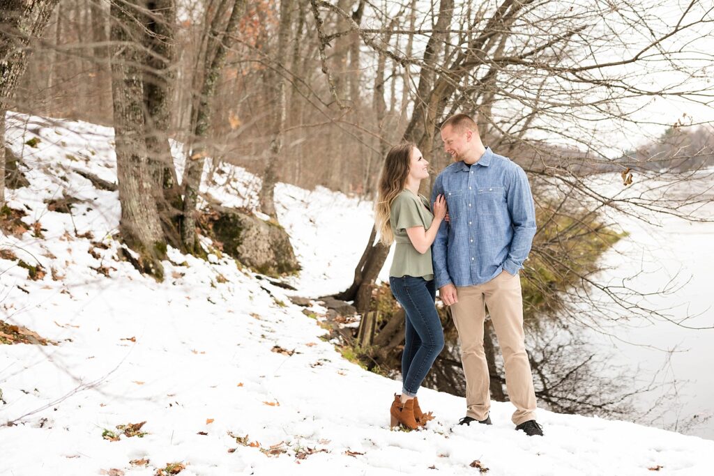 couple standing by the Chippewa River for their winter engagement session in Ladysmith
