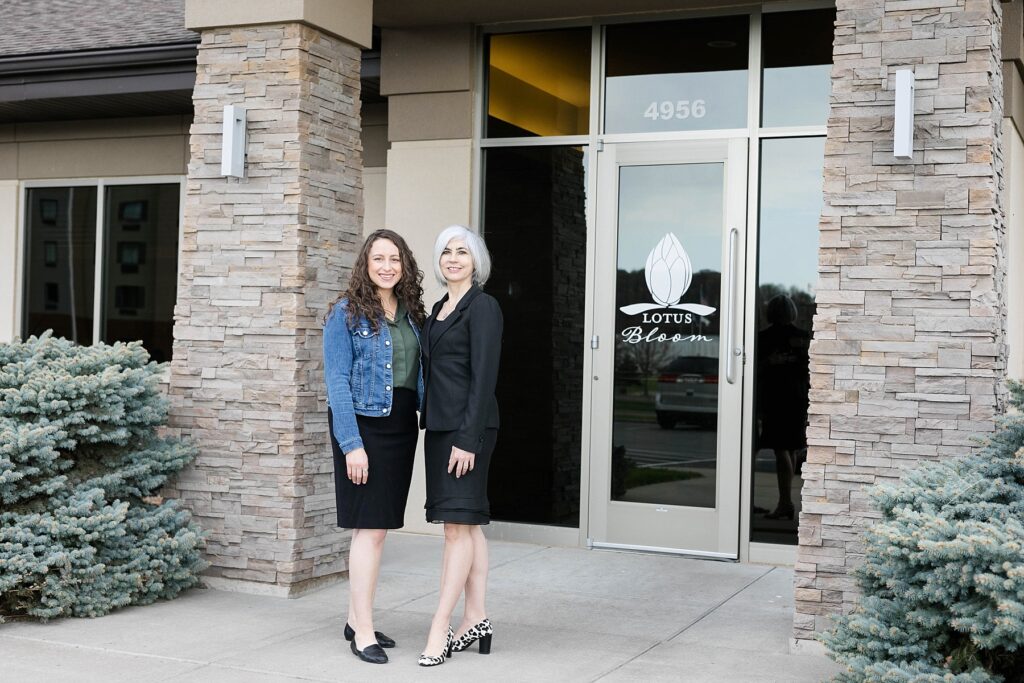 Jenna Barnes and Dr. Michelle Facer stand infront of Lotus Spa Bloom in Eau Claire, WI where they do all of their laser, CoolSculpting and injection treatments.