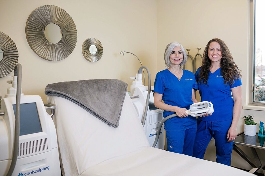 Dr. Facer and Jenna Barnes stand next to their two CoolSculpting machines at Lotus Spa in Eau Claire.